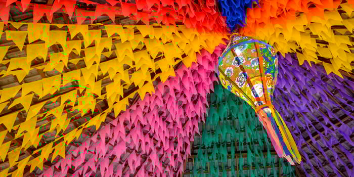 Bandeirolas e balão de São João representando produtos de Festas Juninas para vender online