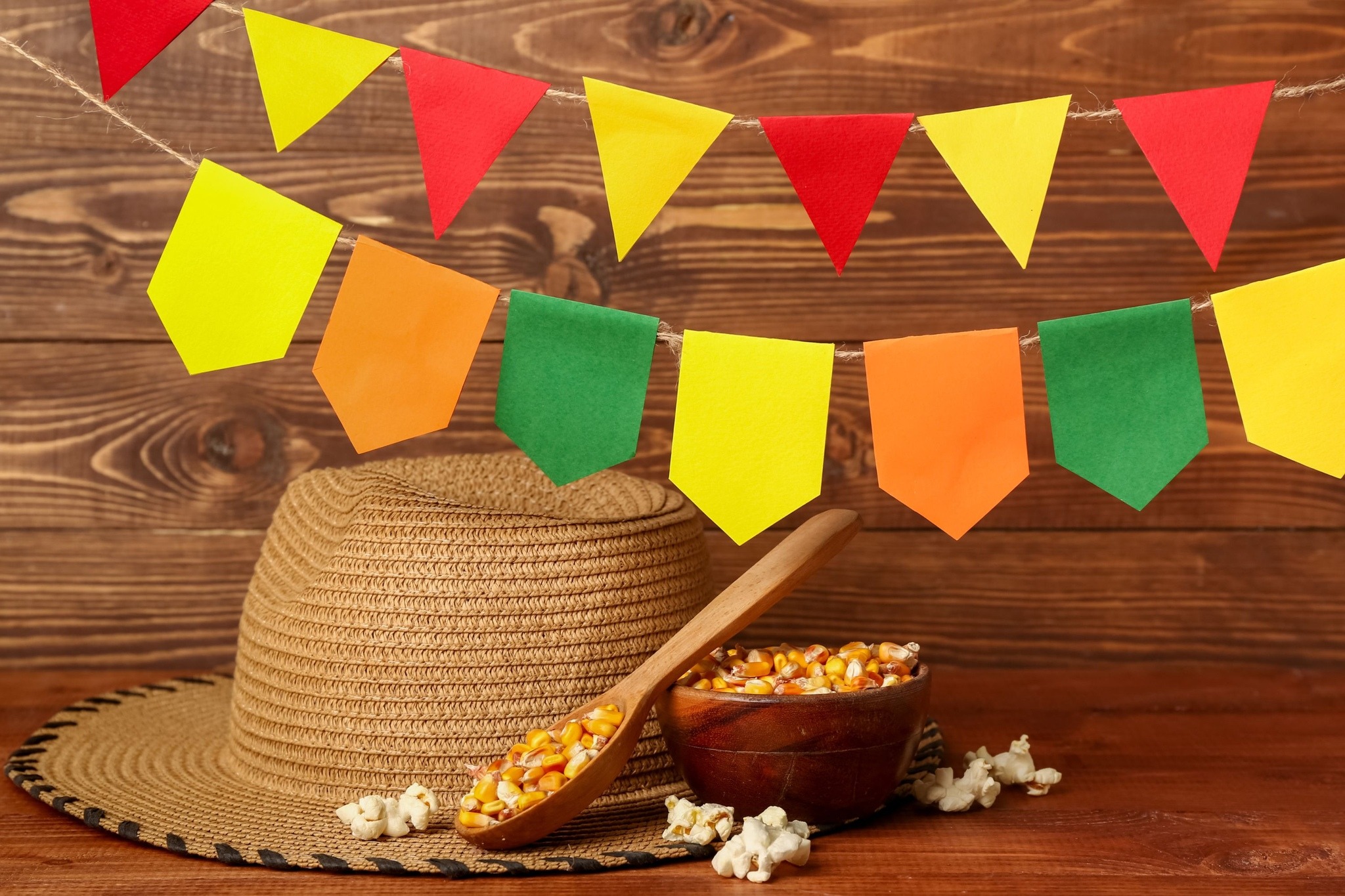 Bandeirolas, chapéu de palha e pipoca representando produtos da Festa Junina