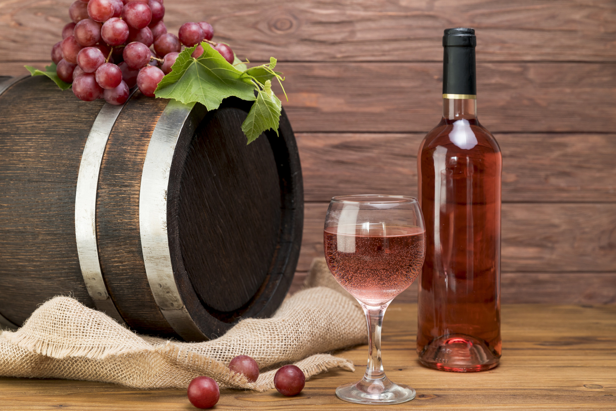 Barril de madeira com garrafa e copo de vinho