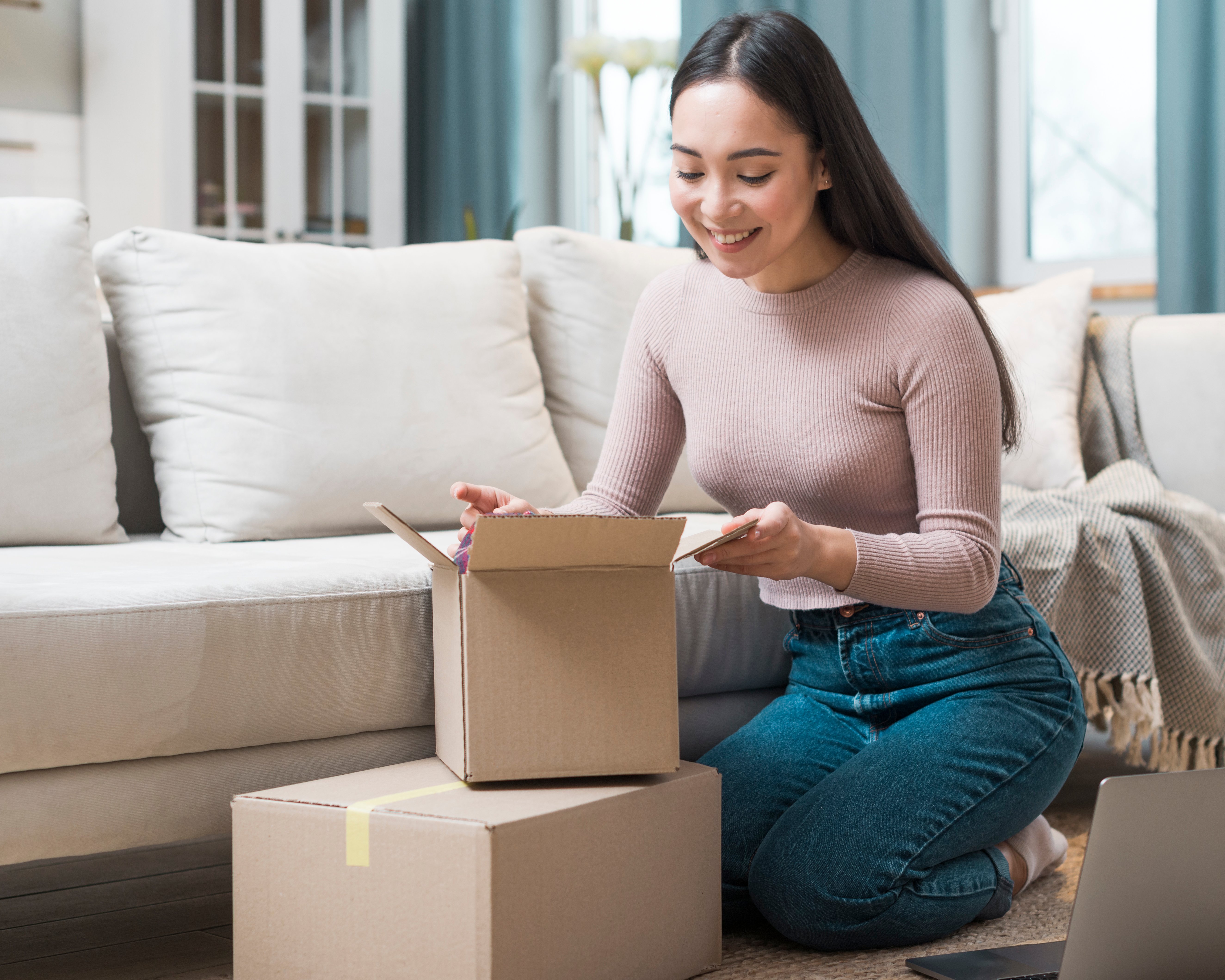 Mujer feliz abriendo paquetes que recibió vía Mercado Libre