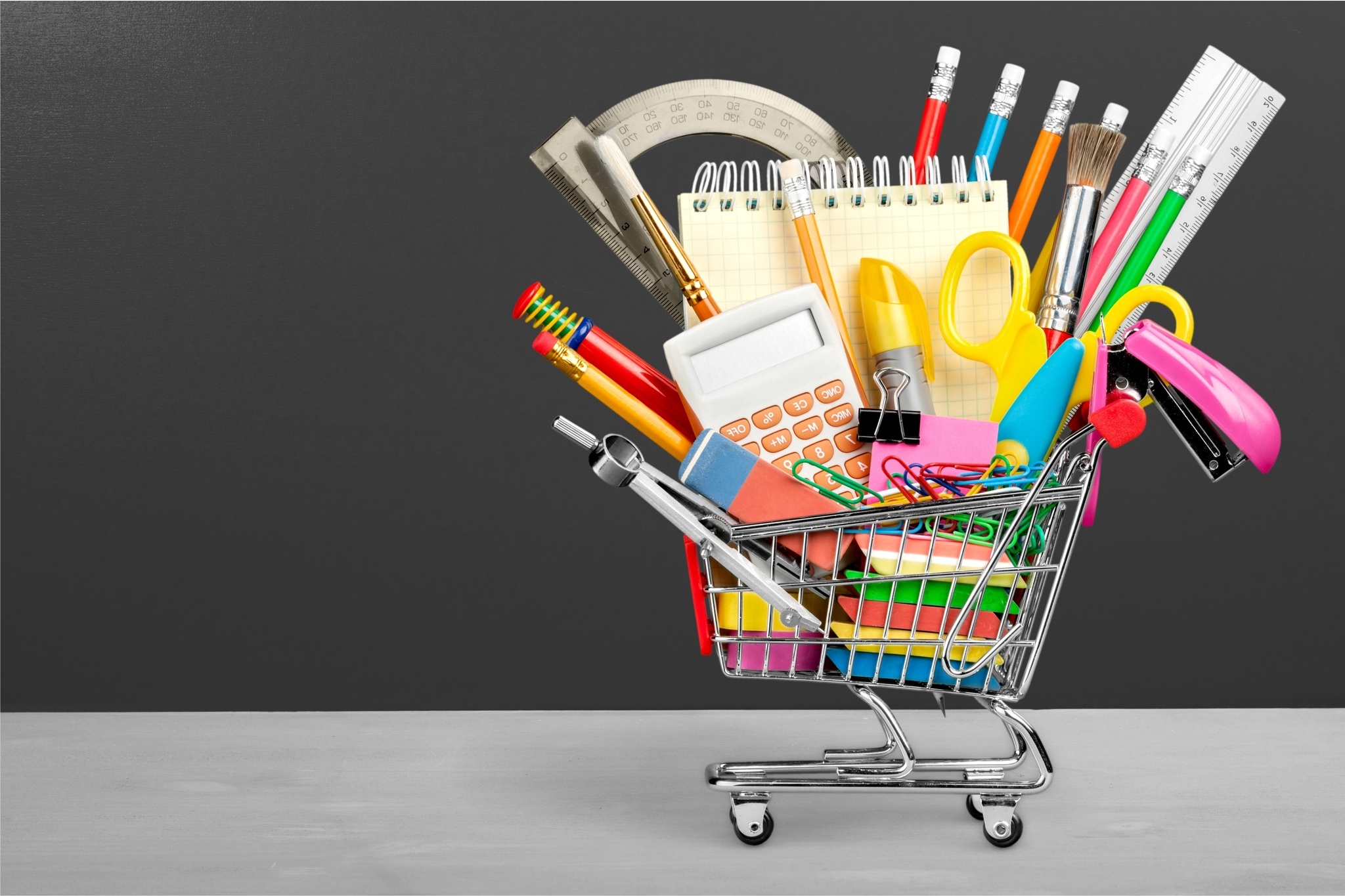 Carrinho de compras com produtos de papelaria representando oportunidades no nicho de papelaria online