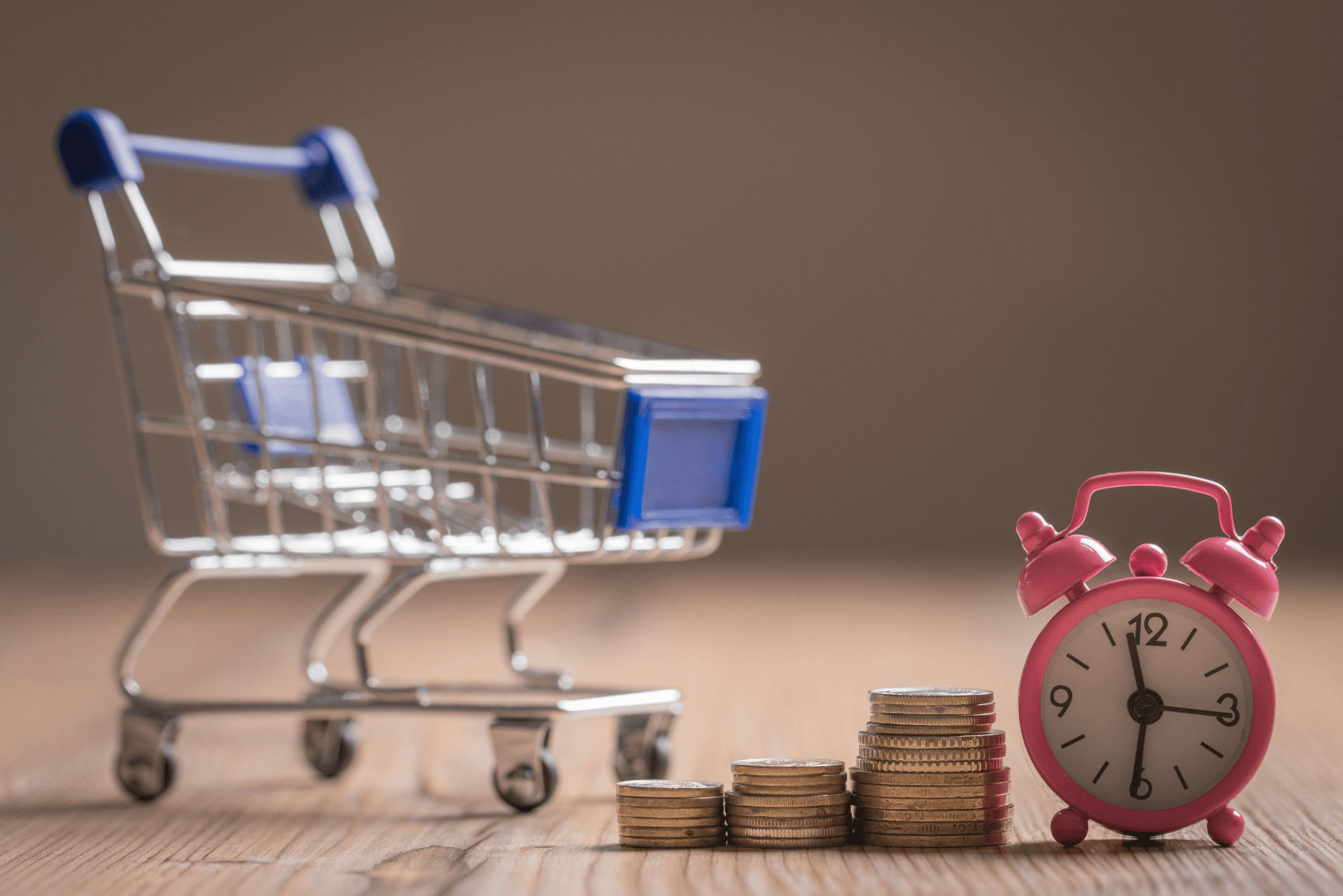 Carrito de compras, monedas y reloj que representan los productos que se venden rápido en Internet