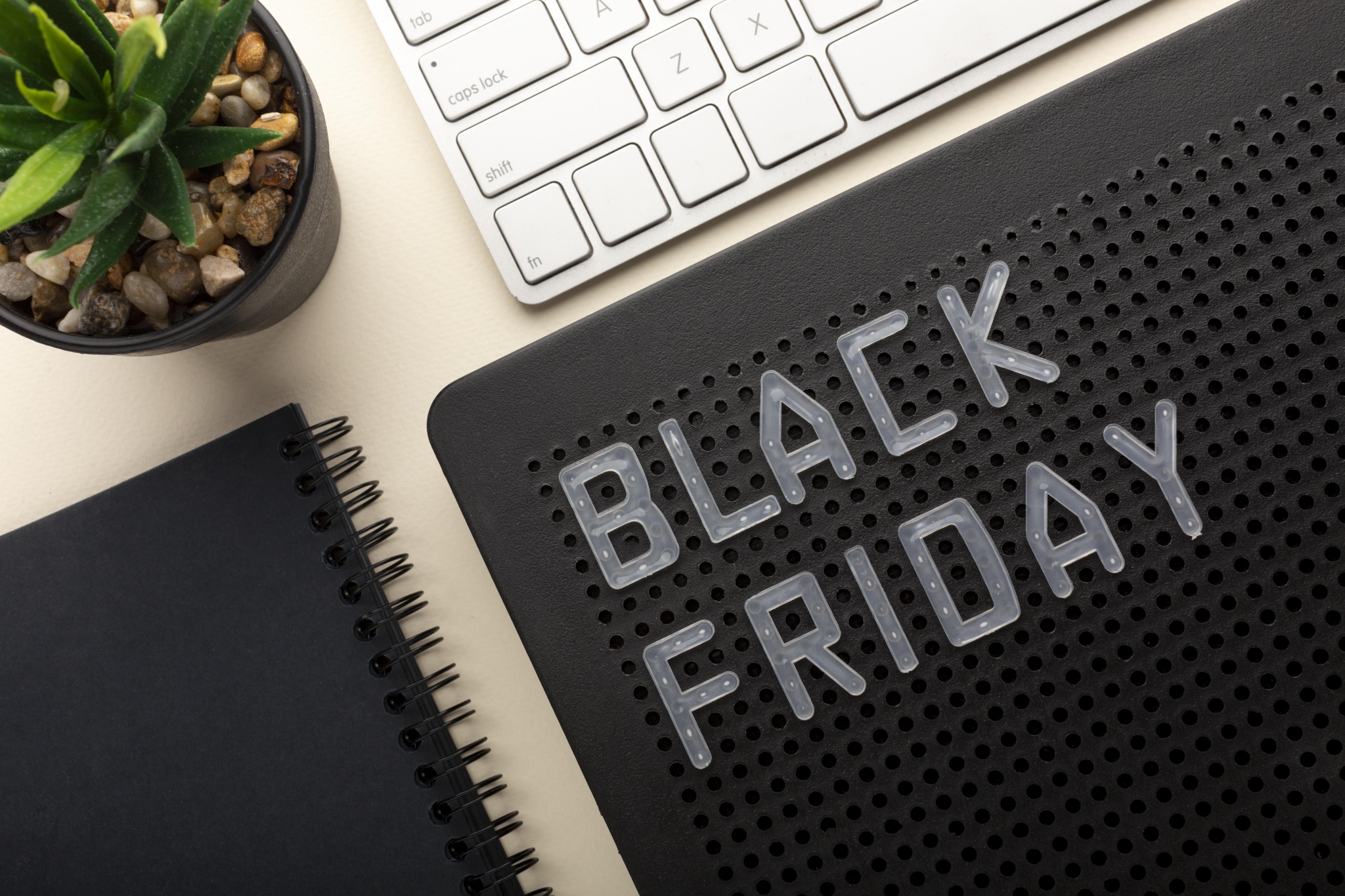 Fundo com teclado de laptop, vaso de plantas e painel escrito Black Friday