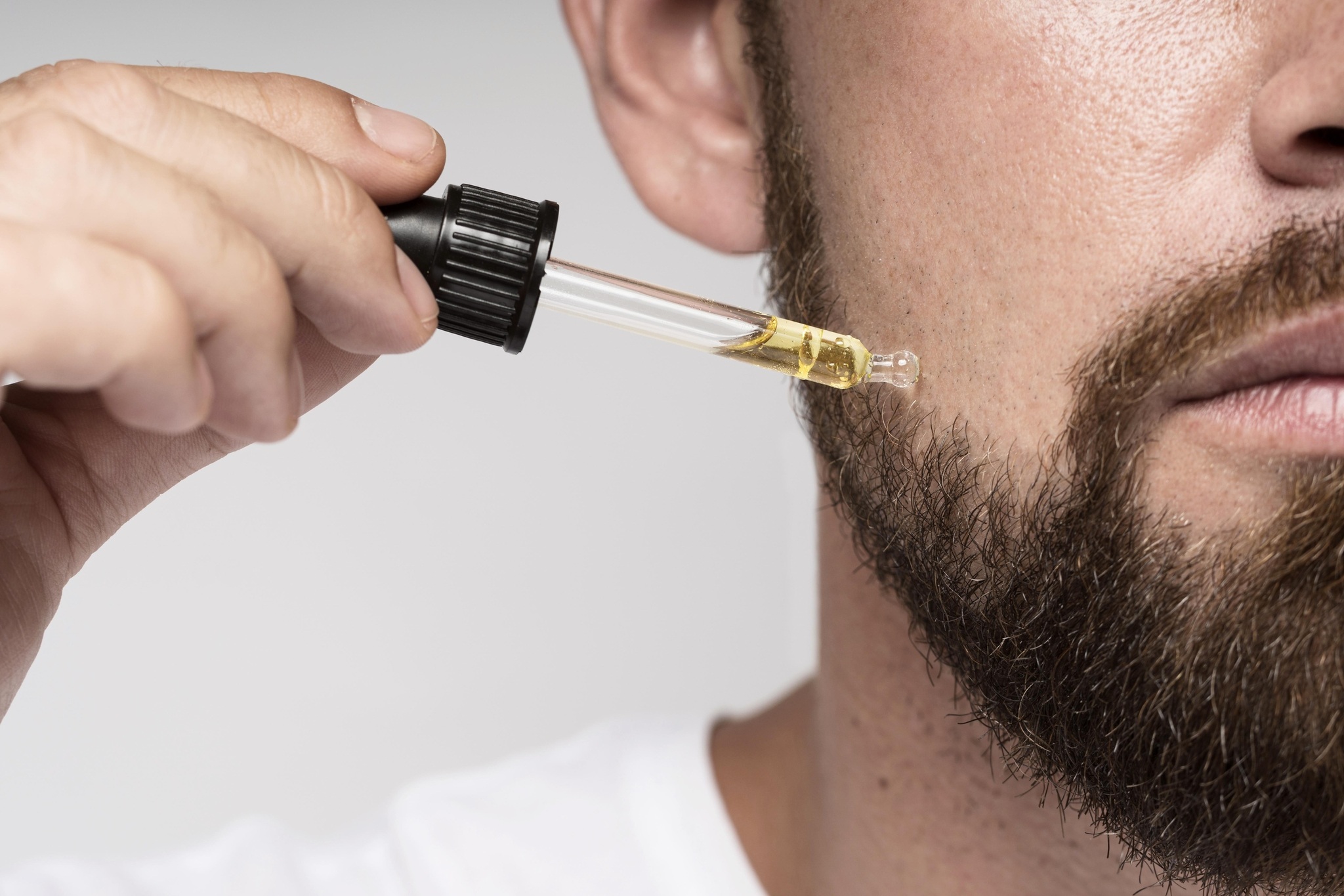 Homem usando óleo para barba representando produtos de cuidados masculinos