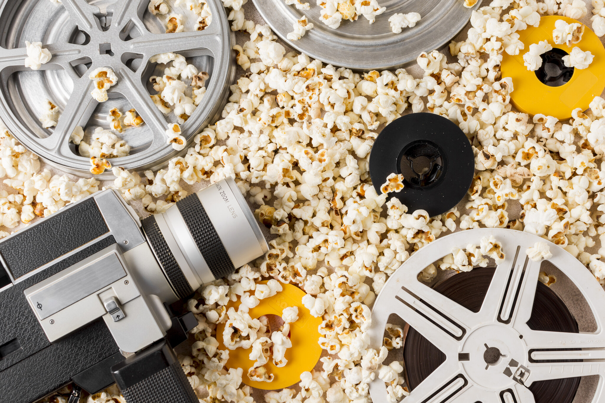 Imagem de rolo de filme e câmera retrõ sobre pipocas representando impacto da ficção no e-commerce