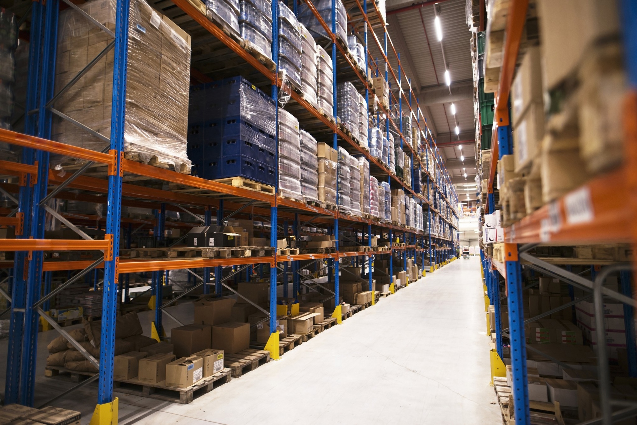 Interior de un gran almacén de distribución con estanterías repletas de palés y productos listos para su comercialización.