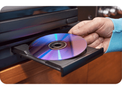 Mão inserindo bluray em reprodutor