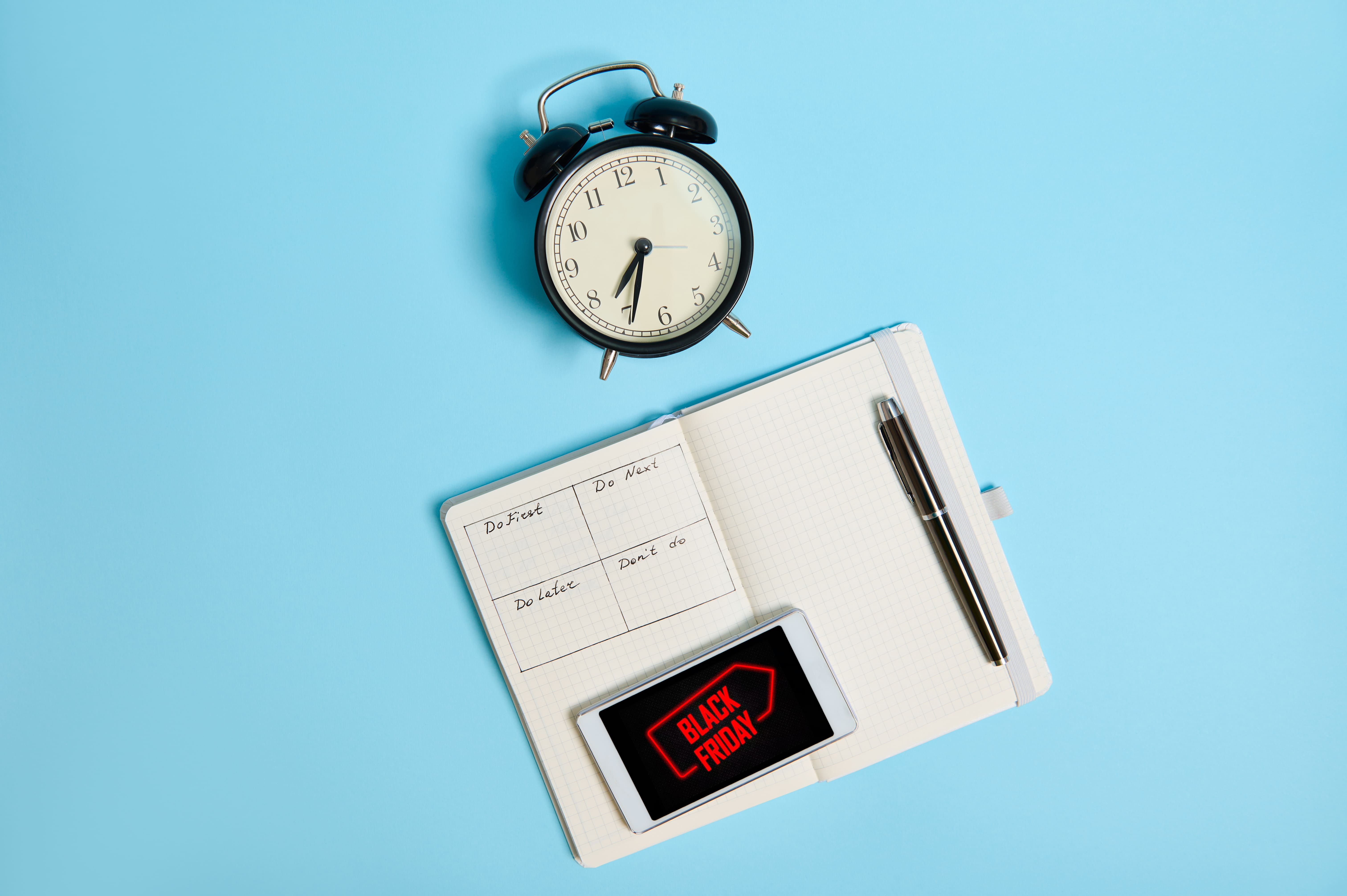 Reloj con cuaderno y celular con logo del Black Friday en Mercado Libre