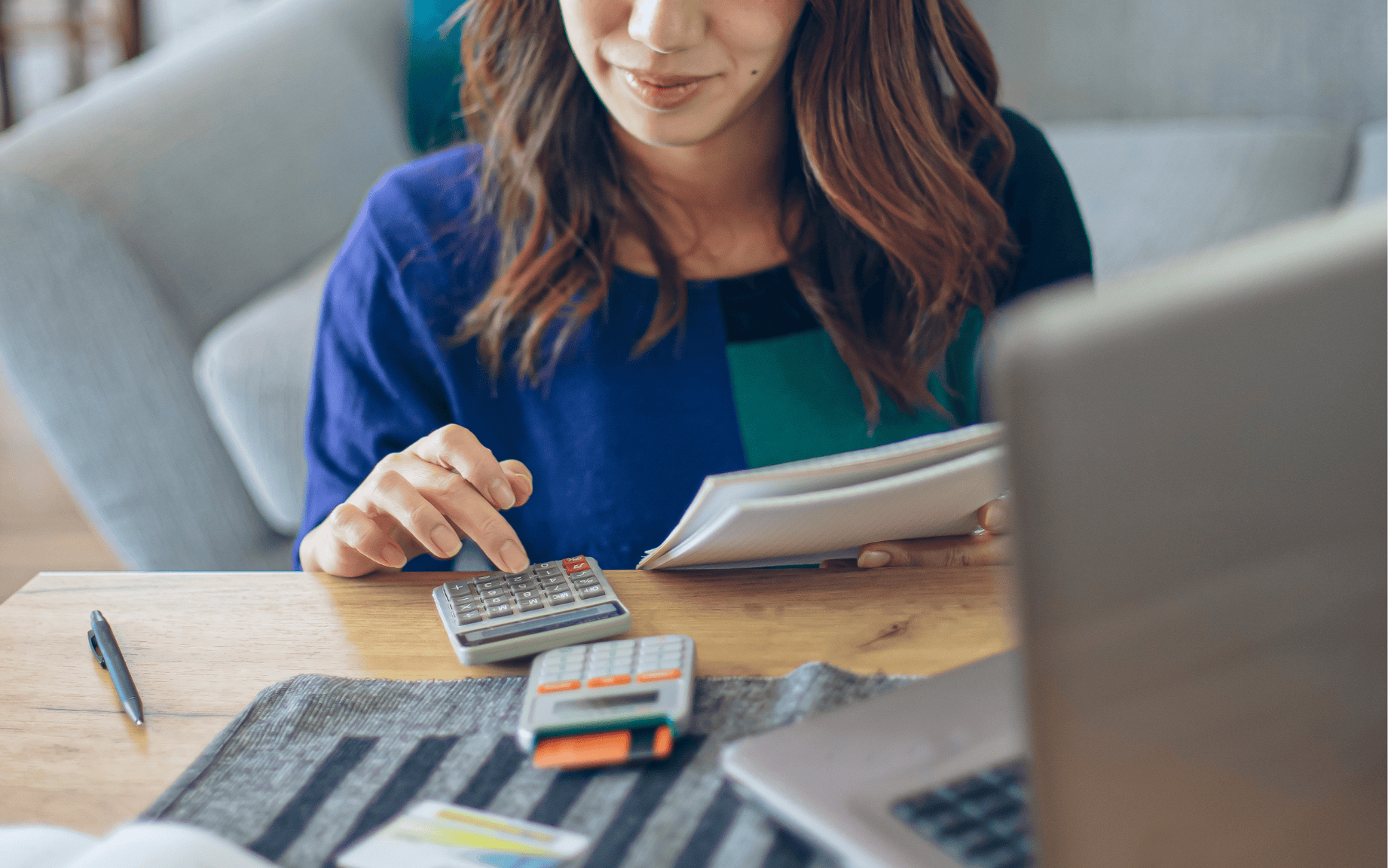 Mujer vendedora con calculadora, computadora y cuaderno representando la acción de fijar precios