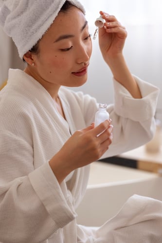 Mulher usando sérum facial representando a k-beauty e os cuidados de skincare coreana