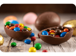 Ovos de Páscoa de chocolate coloridos em mesa de madeira