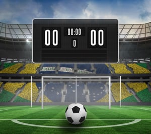 Black scoreboard with no score and football against football pitch in large stadium