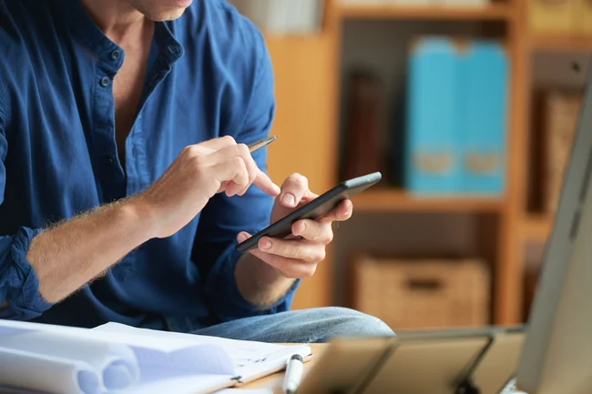 Vendedor pesquisando pelo celular tipos de clientes no e-commece