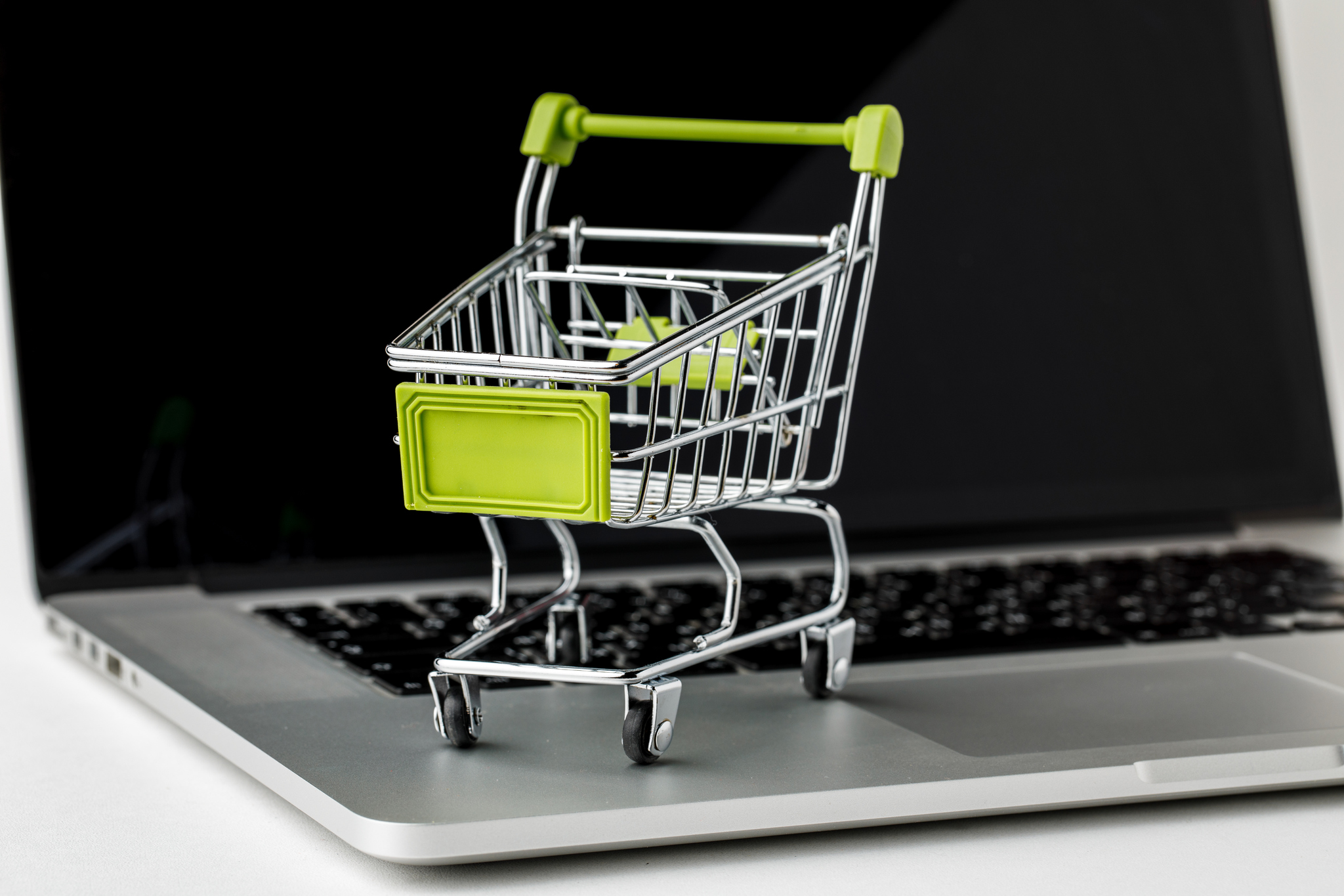 online-shopping-and-ecommerce-basket-and-laptop-on-white-background