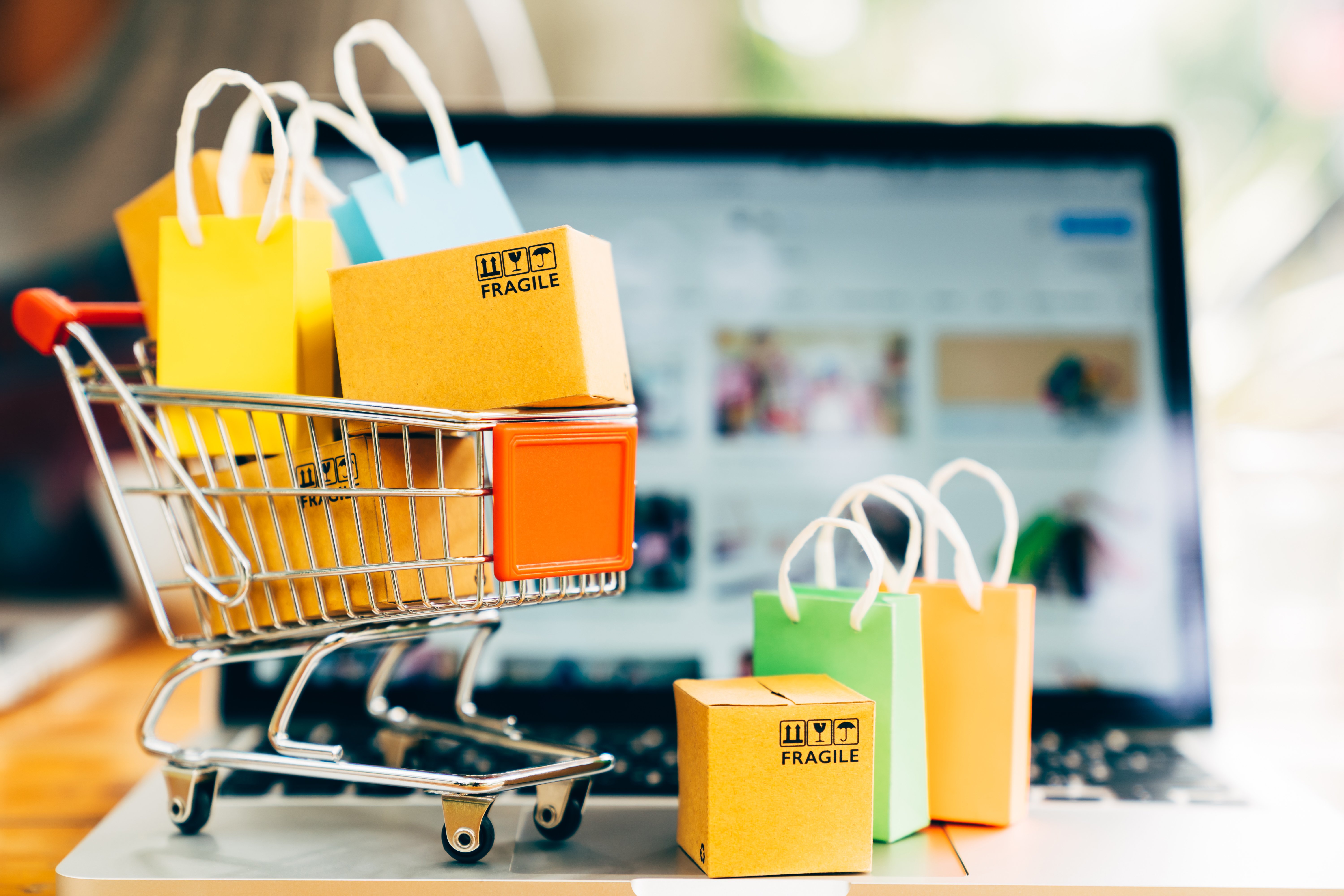 product-package-boxes-and-shopping-bag-in-cart-with-laptop-for-online-shopping-and-delivery-concept