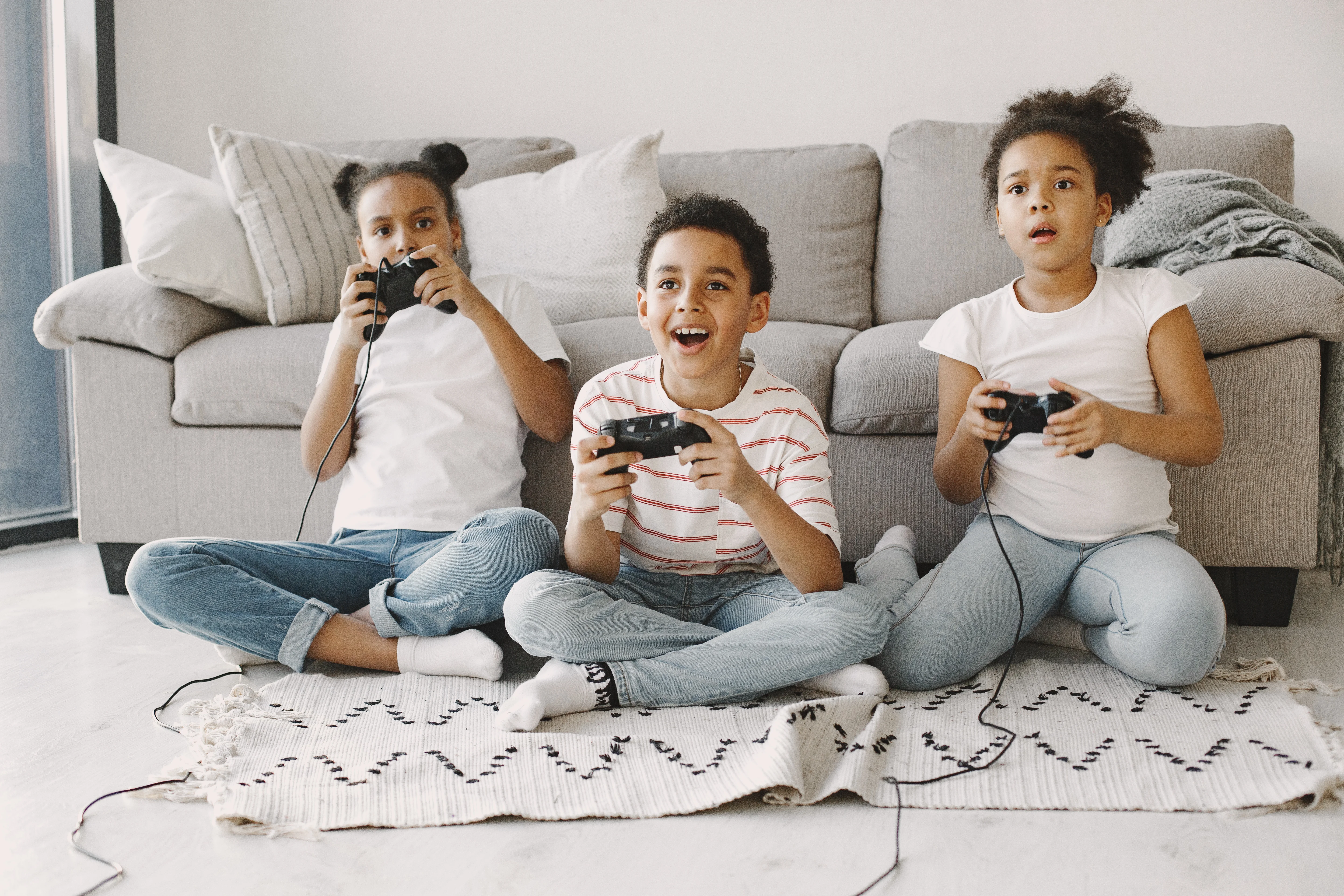 Niños jugando videojuegos con accesorios del universo gamer